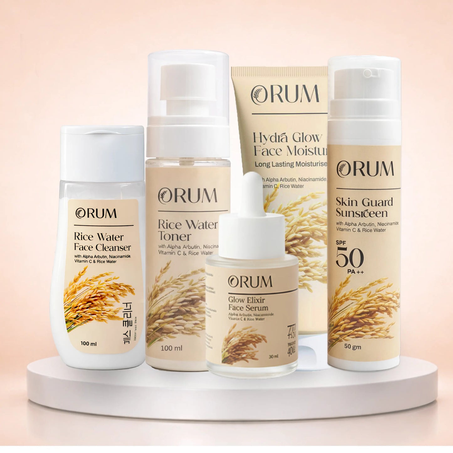 Set of ORUM skincare products standing on a stand against a clean light pink background
